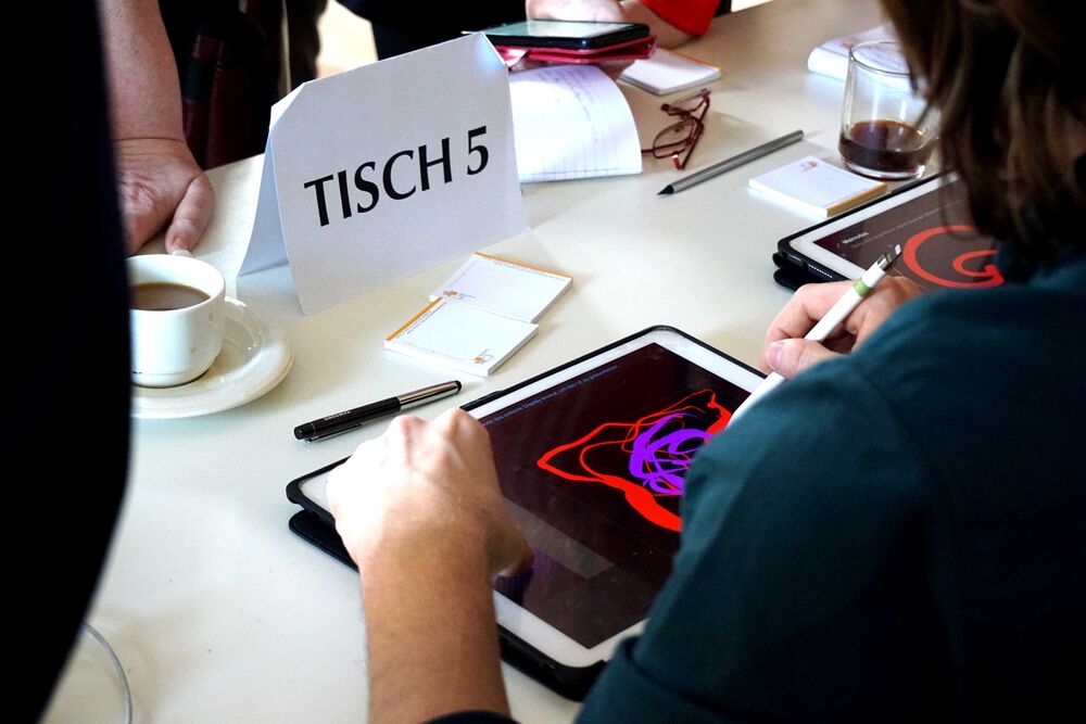 Ein Mensch malt abstrakt mit einem Pen auf einem Tablet