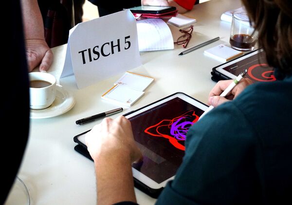 Ein Mensch malt abstrakt mit einem Pen auf einem Tablet