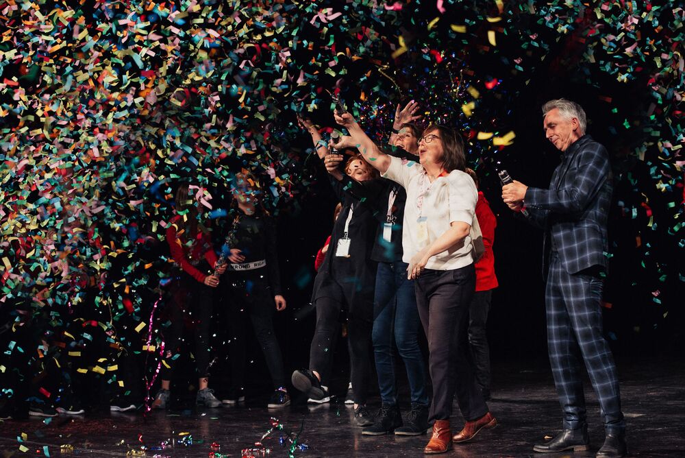 Mehrere Menschen schießen Papierschnipsel Kanonen ab